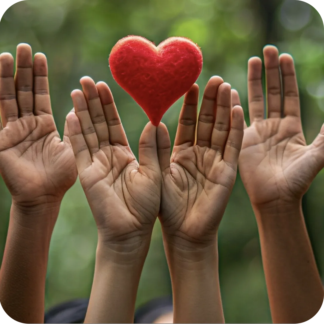 Raised hands surrounding a red heart, representing community care